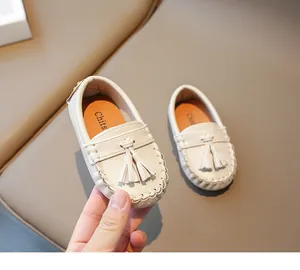 Détail des mocassins crème pour tout-petits avec glands en cuir souple élégants