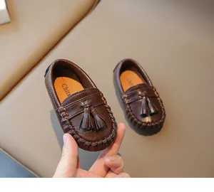 Gros plan de mocassins en cuir marron pour tout-petits avec glands décoratifs