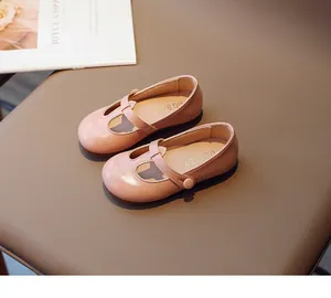 Detailed view of pink toddler girls' Mary Jane shoes with T-strap design on chair