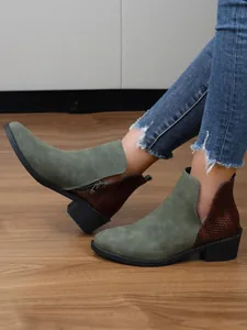 Detailweergave van groen en bruin patchwork enkellaarsjes met blokhak en rits aan de zijkant