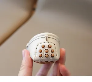 Détail du talon d'un mocassin en cuir blanc pour bébé avec picots antidérapants