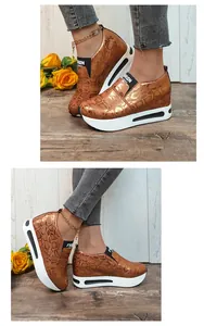 Vista dettagliata di sneakers con zeppa da donna con motivo a serpente e suola platform.