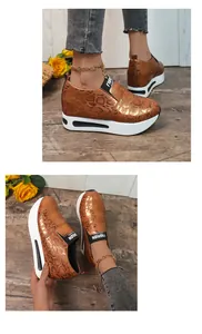 Vista dettagliata delle sneakers con zeppa e suola spessa in pelle di serpente bronzo