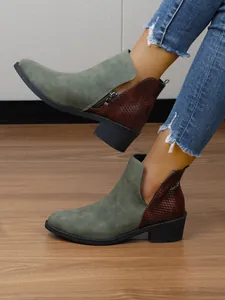 Detailweergave van tweekleurige enkellaarzen met puntige neus en zijrits detail.