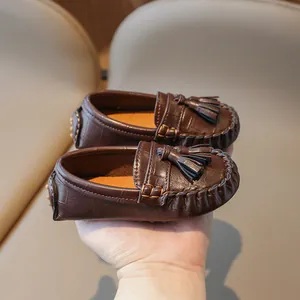 Mocassins classiques marron foncé pour enfants avec pompons et belle texture croco.