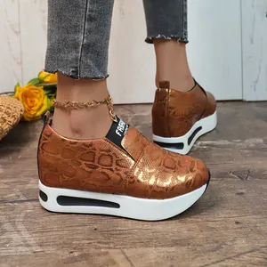 Dettaglio sneaker platform in bronzo metallizzato stampa serpente con cavigliera dorata