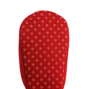 Close-up of red non-slip sole with rubber dots on baby soft-sole shoes