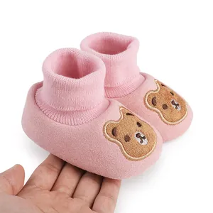 Soft-soled pink baby booties with cute cartoon bear embroidery detail