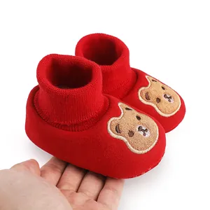 Close-up of red baby winter cotton shoes with cute cartoon bear embroidery