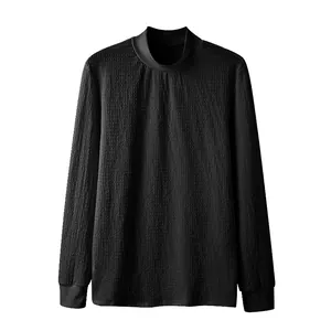 Close-up of black men's mock neck shirt with water ripple textured knit fabric detail.