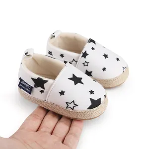 Detalle de zapatos de bebé para caminar con patrón de estrellas negras