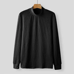 Detailed view of black mock neck t-shirt featuring unique water ripple texture.