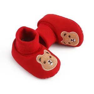 Detail view of red soft sole baby socks featuring a cute embroidered cartoon bear design
