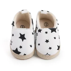 Primer plano de zapatos de bebé con estampado de estrellas negras y suela trenzada