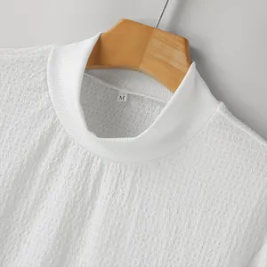 Close-up macro view of a white mock neck shirt showing water wave textured fabric details