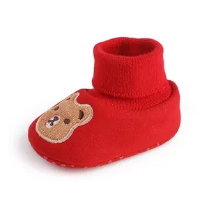 Close-up of red baby winter soft sole sock shoe with a cute cartoon bear embroidery