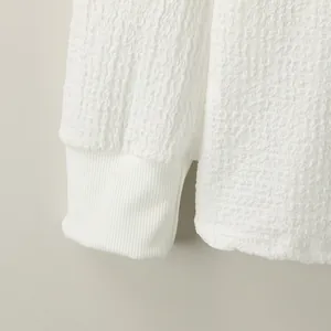 Close-up of white men's knitted T-shirt showing the unique water ripple fabric texture