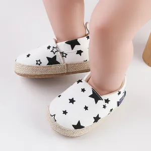 Detalle de zapatos de bebé con diseño de estrellas negras y borde de suela trenzado