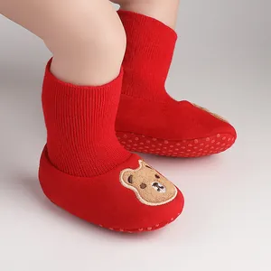 Close-up of red baby indoor shoes with cute bear design and anti-slip sole