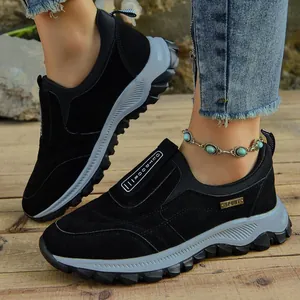 Detalle de zapatillas de exterior negras para hombre en un fondo de madera rústica
