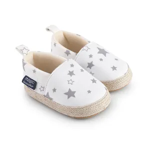 Detalle de zapatos de gateo blancos para bebé con estrellas grises y suela trenzada