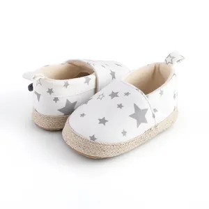 Vista detallada de zapatos blancos de bebé para caminar con estrellas y suela trenzada
