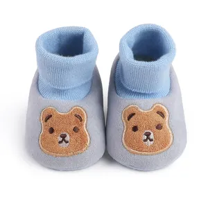Close-up view of baby soft sole shoes featuring a cute embroidered brown bear design
