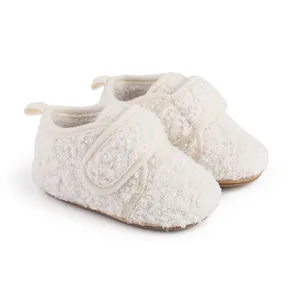 Detailed view of cozy white fuzzy baby winter walking shoes with Velcro strap closure