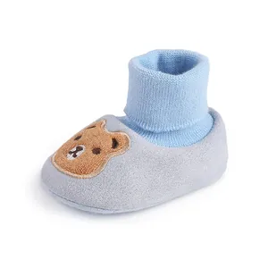 Detail of soft-sole blue baby shoe with cute brown bear embroidery for winter warmth