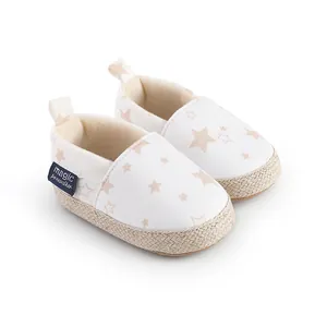 Vista detallada de zapatos de lona blanca para bebé con un lindo patrón de estrellas