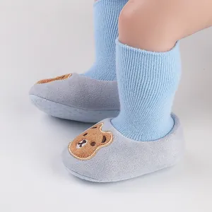 Close-up detail of soft sole baby warm socks shoes with cute cartoon bear embroidery