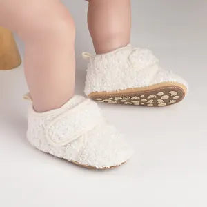Close-up of white fuzzy baby walker shoes with velcro straps and non-slip soles