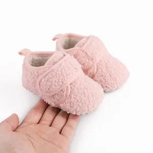 Macro view of pink fuzzy baby booties with warm fleece lining and Velcro closure