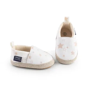 Detalle de zapatos de gateo blancos para bebé con estrellas y borde trenzado.