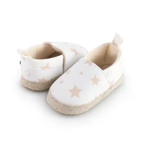 Detalle de zapatos para primeros pasos de bebé con estrellas y suela de esparto