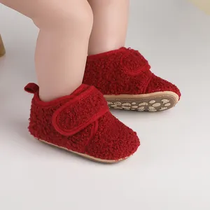 Close-up of cozy red fleece baby walking shoes featuring soft tan anti-slip soles