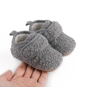 Detailed macro view of grey fleece baby winter shoes featuring soft rubber soles and velcro straps