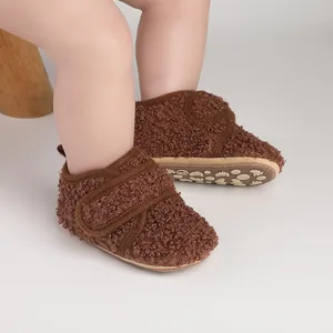 Close-up of brown fleece baby walking shoes with anti-slip patterned rubber sole