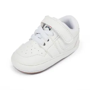 Close-up detail of white baby walking shoe featuring soft laces and a secure velcro strap