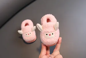 Primer plano de pantuflas de peluche rosa para bebé con cara de cordero adorable