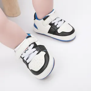 Close-up of black and white baby walking shoes with blue accents on white background