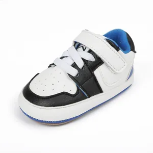 Detailed view of baby walking shoes with white, black, and blue faux leather design