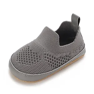 Dettaglio ravvicinato della scarpa da camminata neonato in mesh grigio con suola morbida