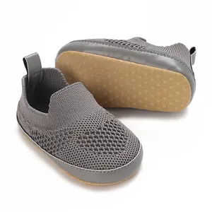 Dettaglio scarpe da camminata per neonati in maglia grigia con suola morbida antiscivolo