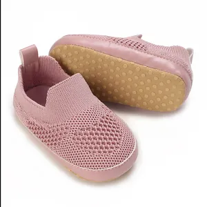 Scarpine da neonato in maglia rosa traspirante con suole antiscivolo con gommini.