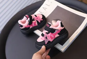 Close-up of pink and black children's winter sneakers with star pattern and plush lining