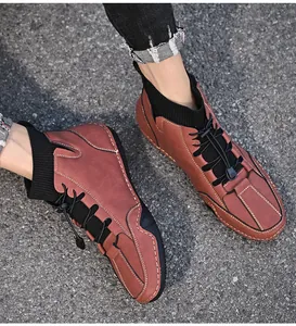 Detailed top-down view of men's reddish-brown mid-top casual sock boots on asphalt