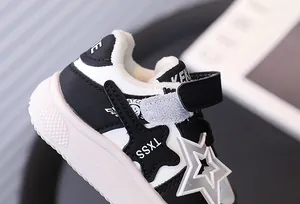 Detail of a children's warm sports shoe with black and white star design and fleece lining.