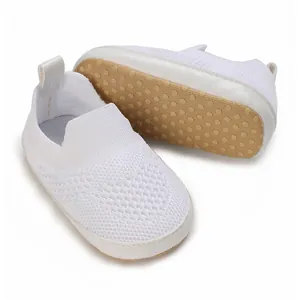 Dettaglio scarpe da camminata neonato in rete bianca con suola morbida a pois