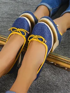 Detail van blauwe geweven sleehakken met stijlvolle gele strikdetails en bies